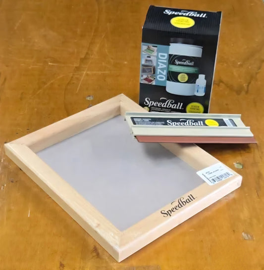Screen printing frame with Speedball products on a wooden surface